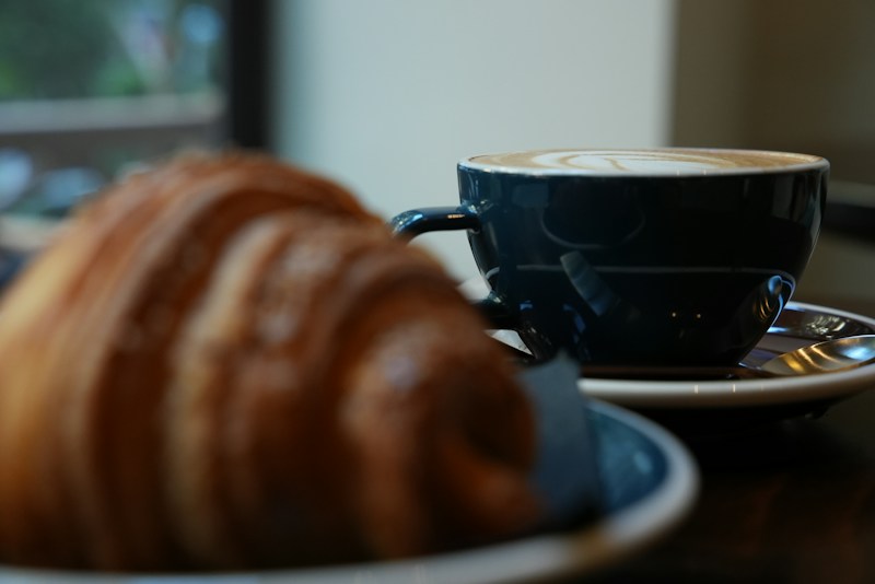 Dark coffee cup and croissant